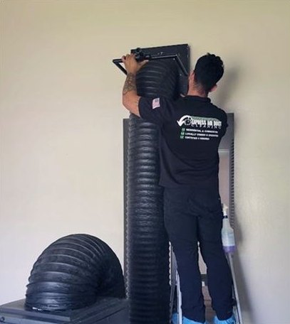 Express Air Duct Cleaning technician connecting a cleaning hose at a return vent