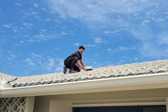 Express Air Duct Cleaning technician working on a tile roof